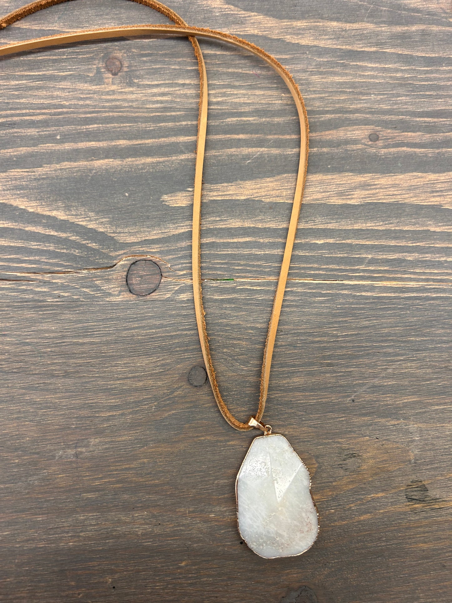 White gemstone necklace on leather chain